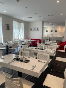 布拉格阿波隆酒店的一间设有白色桌椅的用餐室