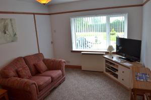 StokeinteignheadPalm Tree Cottage的带沙发和电视的客厅