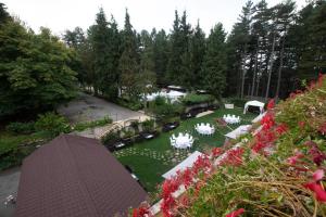 塔瓦娜Parco dei Pini - Sila Wellness Hotel的享有花园的空中景致,配有白色桌椅
