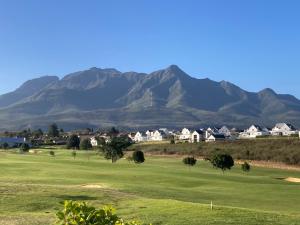 乔治Golfers View @ Kingswood Golf Estate的享有以山脉为背景的高尔夫球场的景致