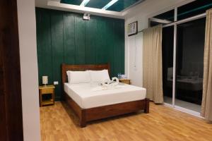 爱妮岛MANANQUIL TRAVEL LODGE的一间卧室配有一张带绿色墙壁的床