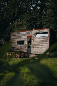 奥纲赖泽Tiny House Célestine By Ernesst的一间小小屋,在草地上有一扇门