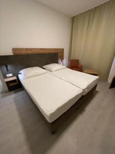 鲁尔河畔米尔海姆Hotel Mintarder Wasserbahnhof的一间卧室配有一张带白色床单的大床