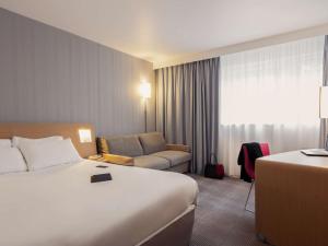 圣维斯Novotel Roissy Saint Witz的酒店客房,配有床和沙发