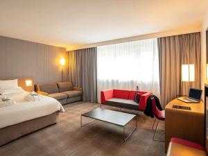 圣维斯Novotel Roissy Saint Witz的酒店客房,配有床和沙发