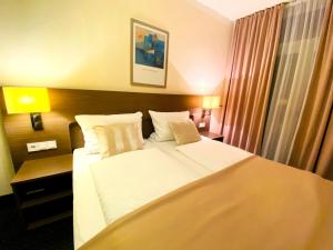 汉堡Hotel Hansehof的酒店客房配有一张带白色床单和枕头的大床。