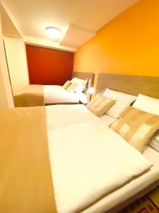 汉堡Hotel Hansehof的橙色墙壁客房的两张床