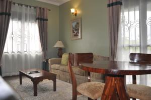 波特尔堡Home Bliss Hotel- Fort portal Uganda的客厅配有桌子和沙发