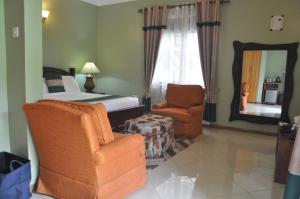 波特尔堡Home Bliss Hotel- Fort portal Uganda的一间卧室配有一张床、一把椅子和镜子