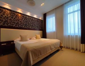 什切青城堡中心酒店的一间卧室设有一张大床和两个窗户。