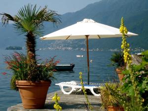 阿斯科纳Ascona: Casa Rivabella的水中的一个白色雨伞和一条船