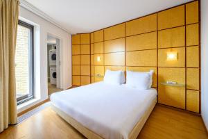 布鲁塞尔蒙哥马利B公寓式酒店的卧室设有一张白色大床和一扇窗户。