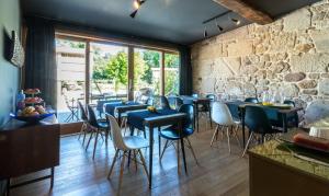 帕德隆奥兹朗曼布兰酒店的一间设有蓝色桌椅和石墙的餐厅