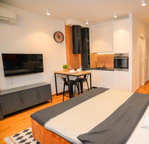 波德戈里察Design Apartment near Gorica Park的一间带大床的卧室和一间厨房