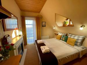 塞伊内Dolina Sarenek的一间卧室配有一张带黄色枕头和镜子的床