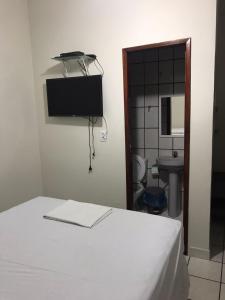 塞古罗港Pousadinha- Melhor Localização的一间卧室配有一张床,浴室设有水槽