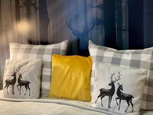 塞伊内Dolina Sarenek的一张带三个枕头的床,上面有鹿