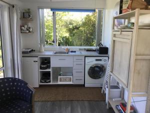 陶朗加Sunset Cottage的厨房配有水槽和洗衣机