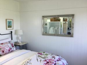 陶朗加Sunset Cottage的卧室配有一张床,墙上设有镜子