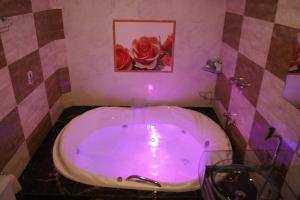 阿雷格里港Motel Desejo的浴室配有带紫色照明的大浴缸