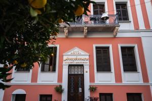 皮尔戈斯文艺复兴精品酒店的一座橙色和白色的建筑,设有阳台