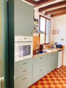 圣艾尼昂L’Alcalys - Maison de vacances au vert - Sans TV的厨房配有白色橱柜和炉灶烤箱。