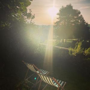 圣艾尼昂L’Alcalys - Maison de vacances au vert - Sans TV的坐在草地上的椅子上,阳光照耀