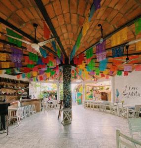 萨尤利塔La Redonda Sayulita Hostal的一间拥有色彩缤纷旗帜天花板的客房