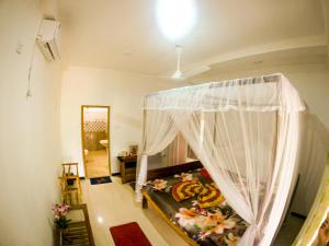 乌纳瓦图纳Villa Sunimal的一间卧室配有一张带蚊帐的床