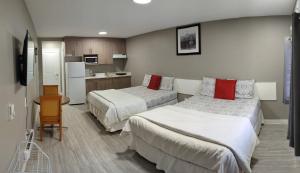 梅迪辛哈特Riverside Motel的酒店客房带两张床和厨房