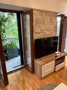 马卡尔斯卡Apartment Old Town Ivo的客厅配有平面电视和滑动玻璃门。