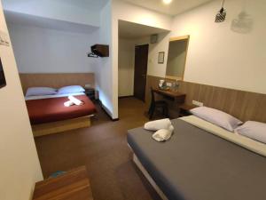 丹那拉打Hillview Inn Cameron Highlands PROMO的酒店客房配有两张床和一张书桌