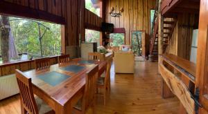 普孔普孔卡瓦尼亚斯自然公园山林小屋的用餐室设有一张长桌,铺有木地板。