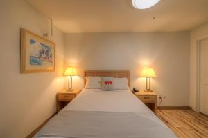 新港Newport Inn By OYO - Hwy 101的一间卧室配有一张大床和两盏灯