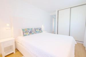 米尔芳提斯城Penthouse with rooftop pool - Duna Parque Group的白色的卧室设有白色的床和窗户。