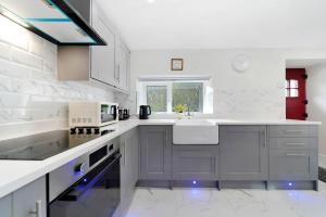 班克拉那Glenside Cottage 'Sleeping 4 guests'的白色的厨房设有水槽和炉灶。