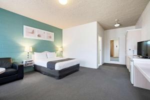 瑟尔国王大道康福特茵套房酒店的一间卧室配有一张床、一张沙发和一台电视