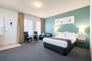 瑟尔国王大道康福特茵套房酒店的酒店客房带一张床、一张桌子和椅子