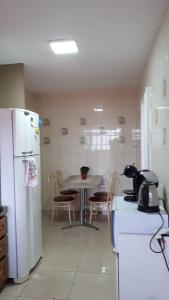 阿雷格里港Manacá House Porto Alegre的厨房配有桌子和白色冰箱。