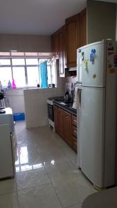 阿雷格里港Manacá House Porto Alegre的厨房配有白色冰箱和木制橱柜。