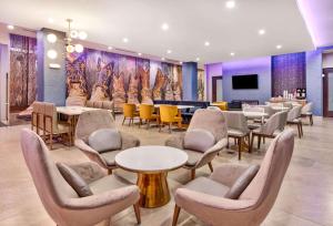 特勒尔La Quinta Inn & Suites by Wyndham Terrell的一间设有桌椅和电视的等候室