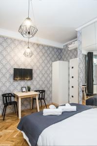 克拉科夫Cracovia Wawel Apartments的一间卧室配有一张床和一张桌子及椅子