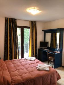尚波尔谢petit paradis的一间卧室配有一张床、一张书桌和一个窗户。