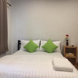 班敦孟The Best House&Hostel的一张带两个绿色枕头的床