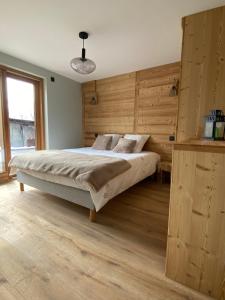 沃雅尼Le terrier的一间卧室配有一张带木墙的大床
