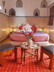 马拉喀什查理玛摩洛哥传统庭院住宅的一间卧室配有一张带桌子和两把椅子的床