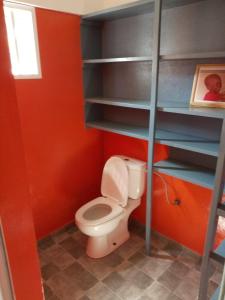 洛美Maison Charlotte Forever Chambre d'hôtes chez un couple belgo togolais的红色墙壁上带卫生间的浴室