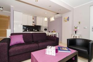 杜布罗夫尼克古拉公寓的客厅配有紫色沙发和桌子