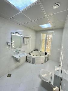 马斯喀特A'Sinamar Hotel Apartment的带浴缸、卫生间和盥洗盆的浴室