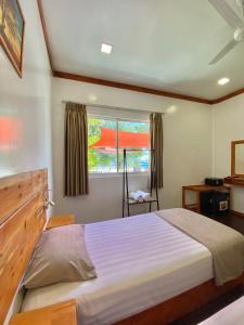 马富施Pelican Beach Maafushi的一间卧室设有一张大床和一个窗户。